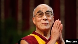 FILE - The Dalai Lama gestures before speaking to students during a talk at Mumbai University.