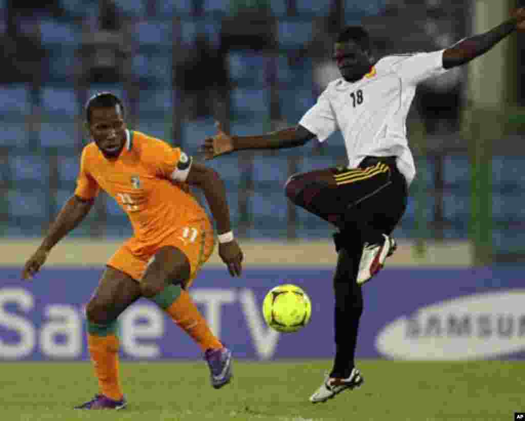 Didier Drogba (L) of Ivory coast fights for the ball with Cabungula Arsenio Sebastiao of Angola during their African Nations Cup soccer match in Malabo January 30, 2012.