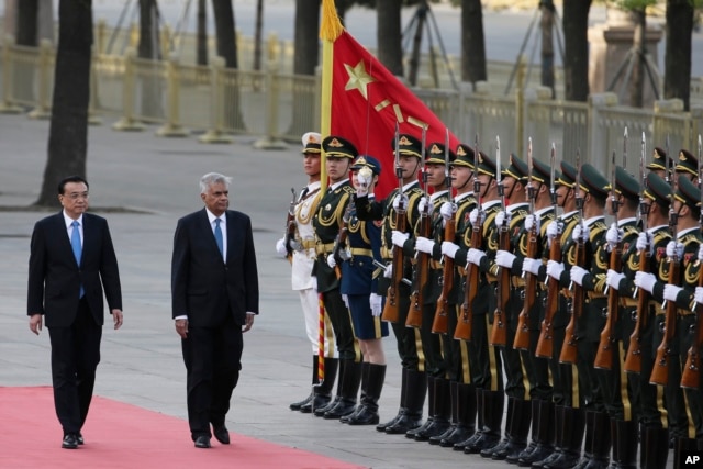 Sri Lankan Prime Minister Ranil Wickremesinghe (2nd L) and Chinese Premier Li Keqiang review an honor guard during a welcome ceremony outside the Great Hall of the People in Beijing on April 7, 2016.