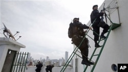 Members of Comando de Operaciones Especiales, or National Police Special Operations Command, take position on the roof of a building in Cartagena, Colombia, April 12, 2012.