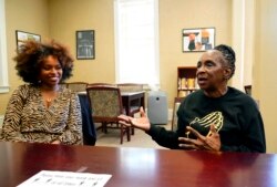 Gloria Green-McCray, right, sister of James Earl Green, discusses the importance quilting plays in the African-American community with Ebony Lumumba, department chair and associate professor of English at Jackson State, Nov. 30, 2021, in Jackson, Miss.