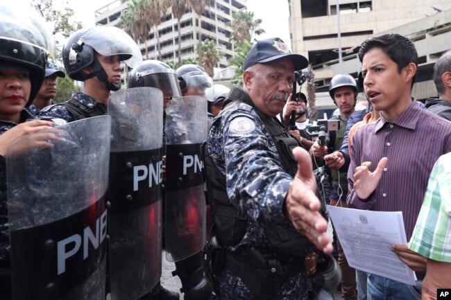 A police officer blocks an opponent to Venezuela's President Nicolas Maduro outside the Navy's headquarter in Caracas, Venezuela, May 4, 2019. Opposition leader Juan Guaido took his quest to win over Venezuela's troops back to the streets.