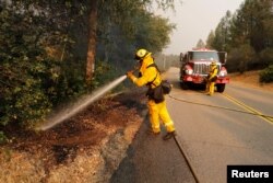 A firefighter knocks down a hot spot while working to stop the spread of the Carr Fire, west of Redding, Calif., July 27, 2018.
