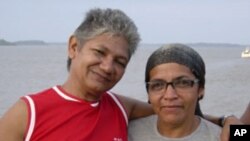 Rubber tapper Jose Claudio Ribeiro da Silva, left, and his wife Maria do Espirito Santo look at the camera in this undated photo in Brazil. Ribeiro da Silva, an activist who was fighting to protect the Amazon rain forest from loggers, was shot and killed 