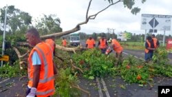 Road workers remove a fallen tree blocking a road near Lami, Fiji, Feb. 21, 2016, after cyclone Winston ripped through the country. Officials in Fiji are assessing damage in the wake of the ferocious cyclone that tore through the Pacific island chain. 