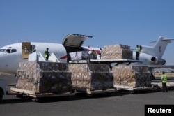 FILE - Workers unload an aid shipment from a plane at the Sana'a airport, Yemen, Nov. 25, 2017.
