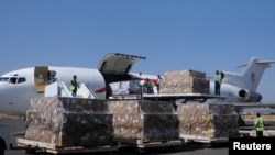 Workers unload an aid shipment from a plane at Sana'a airport, Yemen, Nov. 25, 2017.