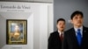 2017年10月13日，被香港媒体认定为前美国中央情报局特工李振成（音译）的男子（打蓝色领带者）站在佳士得香港展厅的保安员前面，身后是达芬奇的画作。
