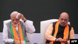 Indian Prime Minister Narendra Modi (L) sits with Bharatiya Janata Party president Amit Shah