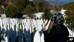 Жінка молиться на меморіальному кладовищі в Поточарі після першого публічного показу фільму боснійської режисерки Ясміли Збаніч про різанину в Сребрениці 1995 року. (AP Photo/Kemal Softic)