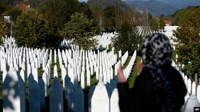 A woman prays at the memorial cemetery in Potocari, after the first public showing of Bosnian filmmaker Jasmila Zbanic's film on the 1995 massacre in Srebrenica. (AP Photo/Kemal Softic)