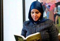 FILE - Samia Omar, Harvard University's first Muslim woman chaplain, reads through "The Chain of Prophets" at the school's office for Muslim chaplains in Cambridge, Mass., Nov. 30, 2021.
