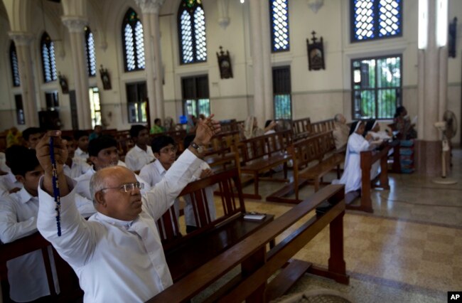 A priest offers prayers with others at the Immaculate Heart of Mary Cathedral in Kottayam in southern Indian state of Kerala, Nov. 4, 2018.