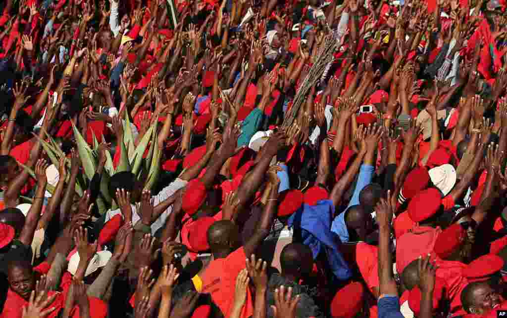Economic Freedom Fighters&#39; (EFF) supporters sing as they raise their hands during their protest outside the South African Broadcasting Corporation (SABC) building in Johannesburg. The march is in protest against the public broadcaster refusing to air the party&#39;s election commercial.
