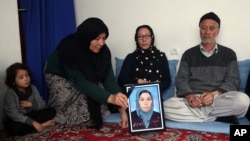 FILE - In this Jan. 28, 2016, photo, a relative holds a picture of Zainab Mirzaee, killed when the Taliban attacked a bus carrying employees of Afghanistan’s biggest media company on Jan. 20.