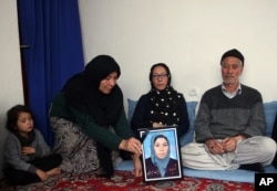 FILE - In this Jan. 28, 2016, photo, a relative holds a picture of Zainab Mirzaee, killed when the Taliban attacked a bus carrying employees of Afghanistan’s biggest media company on Jan. 20.