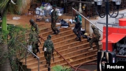Kenya Defense Forces soldiers move at the main entrance of Westgate shopping centre, on the fourth day since militants stormed into the mall, in Nairobi, Sept. 24, 2013. 