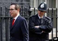 US Secretary of the Treasury Steven Mnuchin walks past a police officer at Downing Street to meet Britain's Chancellor Philip Hammond in London, March 16, 2017.