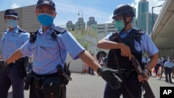 当香港首位被控涉嫌违反国安法的唐英杰坐着轮椅被押解至法院时港警戒备（2020年7月6日）