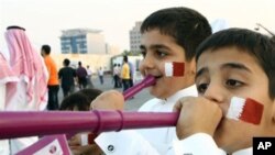 Qatari boys with their faces painted in the colors of their national flag, blow vuvuzelas, celebrating the emirate's selection as the host for the 2022 World Cup, Doha, 02 Dec 2010