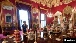 Une employée au travail lors d'une exposition spéciale au palais de Buckingham à Londres, en Grande-Bretagne, le 17 juillet 2019. REUTERS/Toby Melville