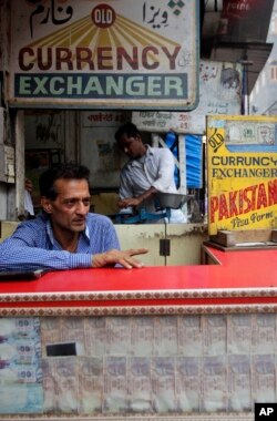 A currency exchanger waits for customers in New Delhi, June 13, 2013.