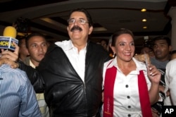 FILE - Free Party presidential candidate Xiomara Castro, right, and her husband, ousted President Manuel Zelaya, leave after giving a press conference before partial election results were announced in Tegucigalpa, Honduras, Nov. 24, 2013.