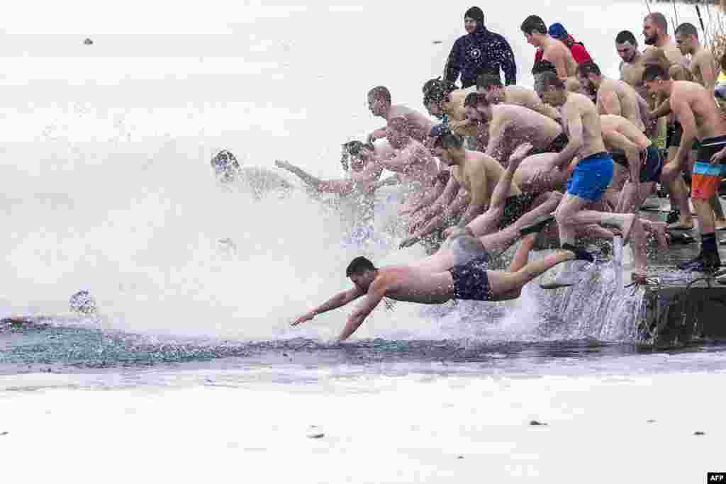 Orthodox faithful dive into the icy winter water of a lake in Sofia, Bulgaria, to catch a wooden crucifix during the Epiphany Day celebrations.