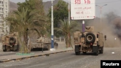 Military vehicles of the Southern Resistance fighters move during clashes with Houthi fighters on a street in Yemen's southern port city of Aden, July 17, 2015.