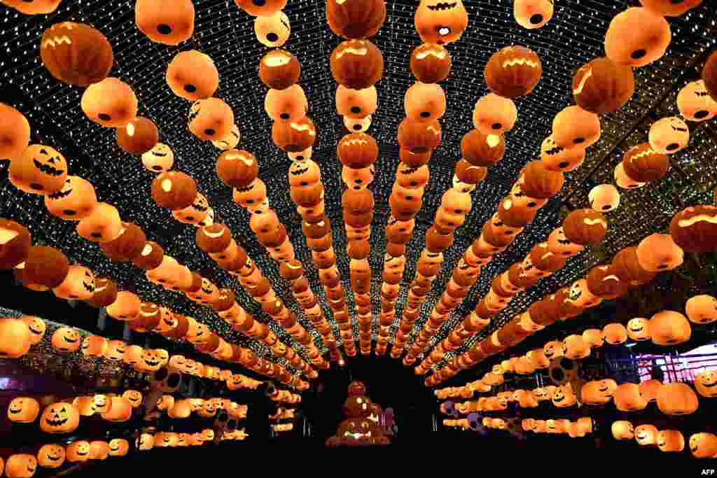 Visitors walk past a pumpkin lantern show in front of a shopping mall to mark Halloween in Shenyang, northeast China's Liaoning province.