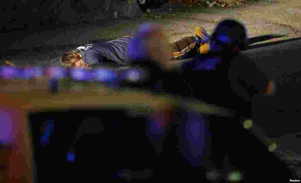 Police officers keep a man on the ground in Watertown, Massachusetts April 19, 2013 following the shooting of a police officer at the Massachusetts Institute of Technology (MIT). 