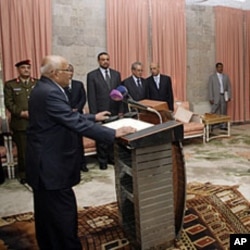 Yemen's newly appointed Prime Minister Mohammed Salem Basindwa (front L) takes the oath of office at the Republican Palace in Sana'a, December 10, 2011.