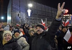 Anti-government protesters march through central Warsaw on the anniversary of imposition of the 1981 martial law by the country's former communist regime, in Warsaw, Poland, Tuesday, Dec. 13, 2016.