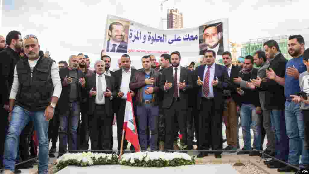 Supporters of Prime Minister Saad Hariri stand in front of the grave his father, Rafik, in Beirut, Lebanon, Nov. 22, 2017.