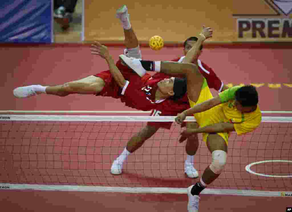Thailand&#39;s Supachai Maneenat, left, returns a shot from Myanmar&#39;s Aung Pyah Tun, right, during their men&#39;s sepaktakraw match at the Southeast Asian (SEA) Games in Naypyitaw, Burma.