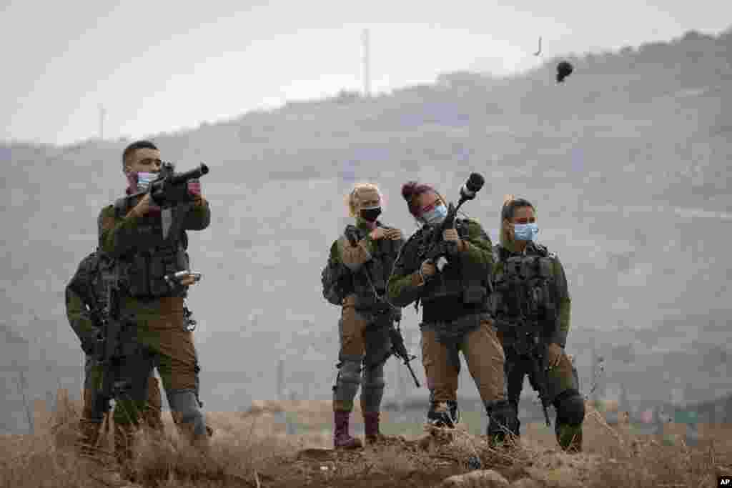 Israeli soldiers fire tear gas towards Palestinian demonstrators during a protest against the expansion of Israeli settlements near the West Bank village of Aqraba, north of Nablus.