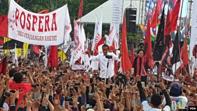 Capres 01 Joko Widodo bersama Megawati Soekarnoputri menyapa pendukungnya dalam kampanye di Solo, Selasa (9/4). (Foto: VOA/Yudha)
