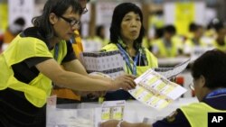 Pera petugas pemilu melakukan perhitungan kartu suara dalam pemilu parlemen di Hong Kong (10/9). 