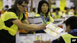 Electoral officers count ballots at the central ballot counting station after legislative elections in Hong Kong, Monday, Sept. 10, 2012.