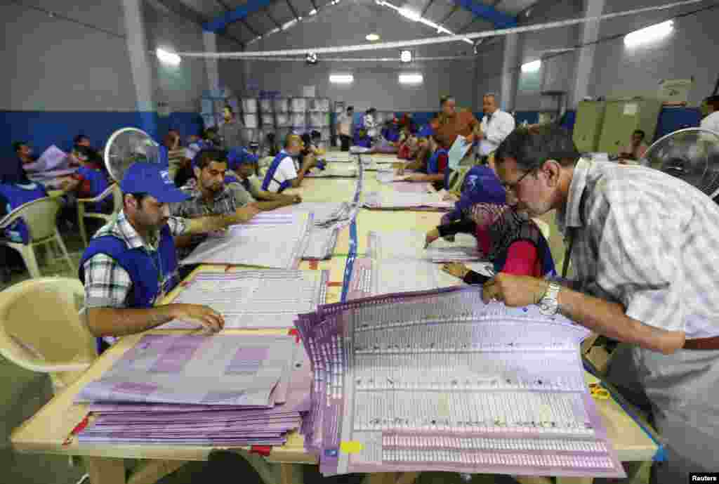 Employees of the Independent High Electoral Commission take part in vote counting at an analysis center in Baghdad, Iraq.