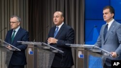 Turkey's EU Affairs Minister Omer Celik, right, Foreign Minister Mevlut Cavusoglu, center, and Finance Minister Agbal Nihat address the media after an EU Turkey Accession Intergovernmental Conference at the EU Council building in Brussels, June 30, 2016.