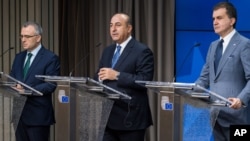 Menlu Turki Mevlut Cavusoglu (tengah) dan Menteri urusan Uni Eropa Turki Omer Celik memberikan keterangan kepada media di Brussels, Kamis (30/6) setelah pertemuan yang membahas keanggotaan Turki dalam Uni Eropa. 