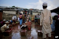 Rohingya refugees perform ablution before offering Eid al Adha prayers at Kutupalong refugee camp, Bangladesh, Wednesday, Aug. 22, 2018.