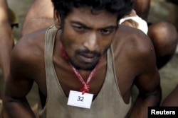 Seorang migran yang ditemukan di sebuah perahu dekat dermaga Kanyin Chaung mengenakan tanda identitas di lehernya.