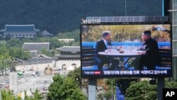 A TV screen shows a photo of South Korean President Moon Jae-in and North Korean leader Kim Jong UN, right, to advertise upcoming Seoul Defense Dialogue in Seoul, South Korea, Sept. 5, 2018. The sign read: "Peace on the Korea Peninsula."