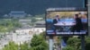 FILE - A TV screen shows a photo of South Korean President Moon Jae-in and North Korean leader Kim Jong Un, right, to promote the Seoul Defense Dialogue in Seoul, South Korea, Sept. 5, 2018. The sign reads: "Peace on the Korean Peninsula."