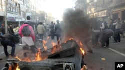 Iranian anti-government protesters set a garbage can on fire, in Tehran, Iran, February 14, 2011