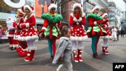 "Kim Ji-young, Born 1982" tells about the common sexism girls and women face in South Korea. Here, a girl walks in front of performers to promote Christmas season at a shopping district in Seoul on November 13, 2017. 