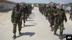 FILE - Members of Somalia's al- Shabab militant group march on the outskirts of Mogadishu, Somalia, March, 5, 2012. A U.S. drone strike Friday reportedly killed a top al-Shabab recruiter.