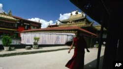FILE - A Tibetan monk walks along the halls of the Jokhang Buddhist temple in Lhasa, Tibet.
